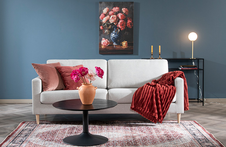 Väriä voi tuoda lisää sisustukseen koristetyynyjen, torkkupeiton ja taulun avulla.